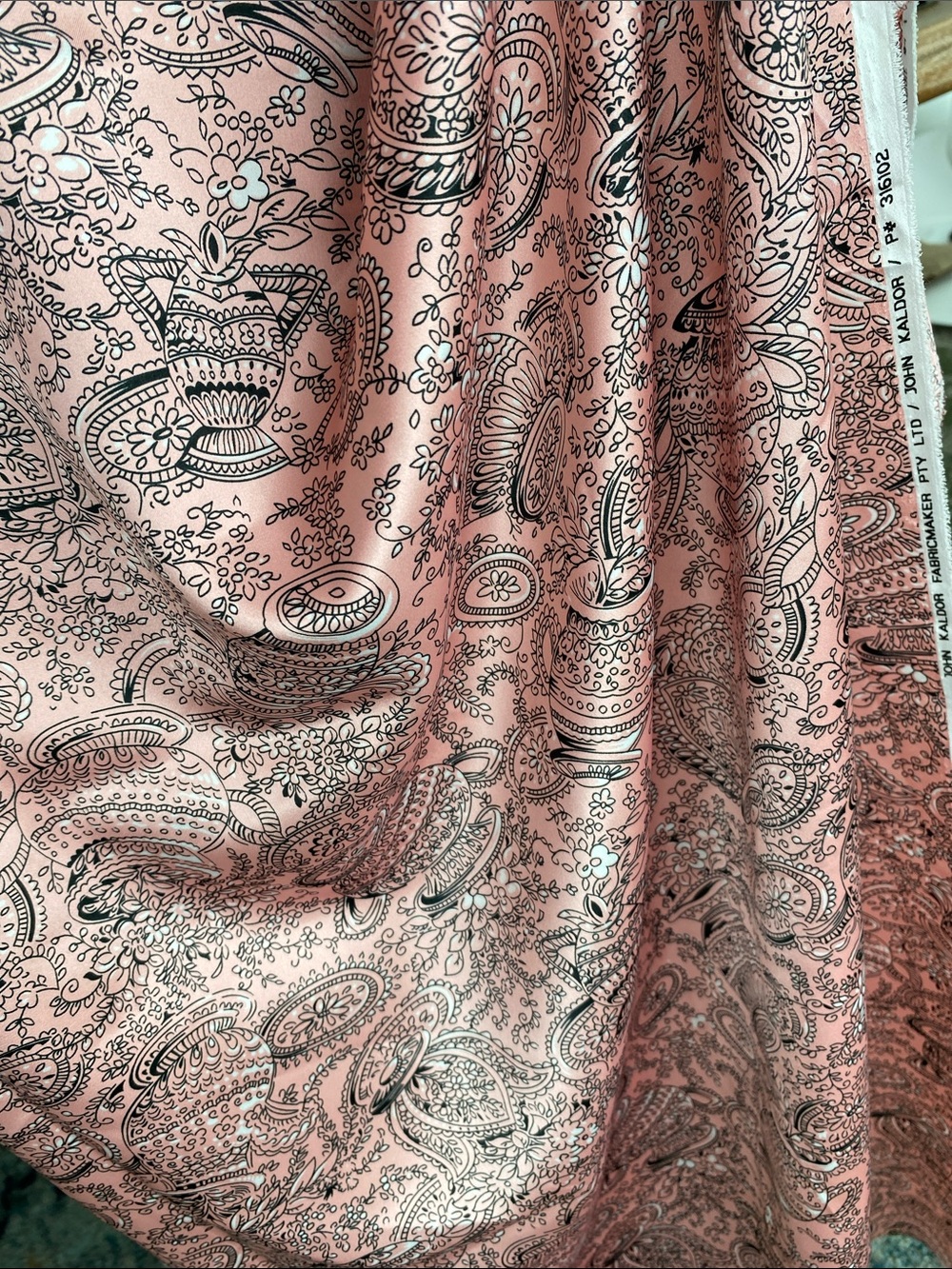 Soft pink silken fabric with intricate black and white pottery/paisley design